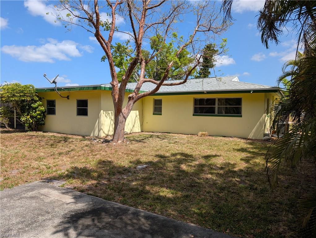 1630 South Fountainhead Road Fort Myers, FL 33919 - Photo 21 of 29 Rear view of house with stucco siding and a yard
