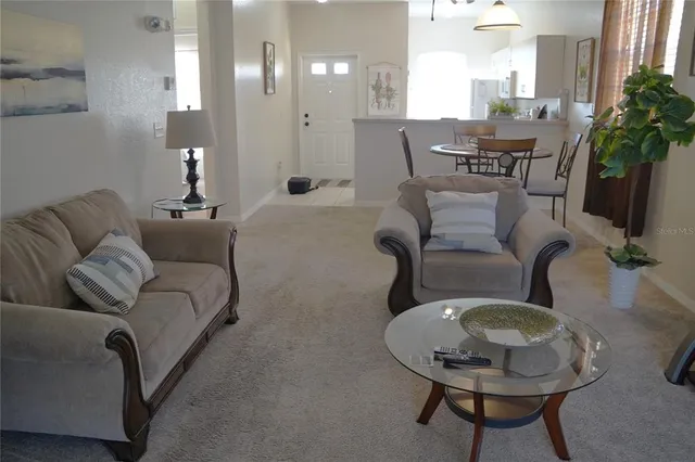 a living room with furniture a chandelier and a flat screen tv