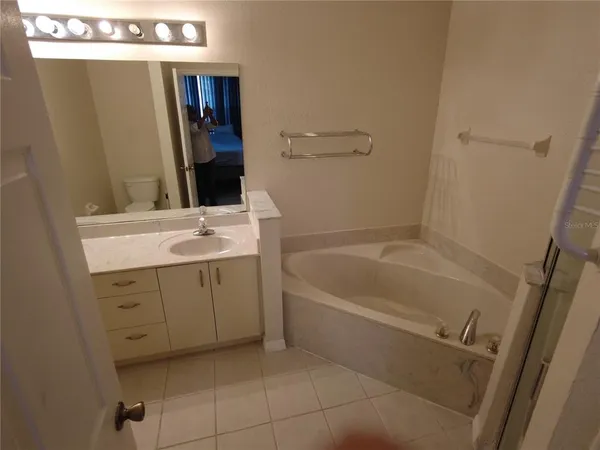 a bathroom with a tub sink and mirror