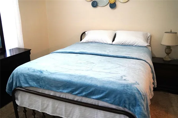 a large bed sitting in a bedroom next to a lamp