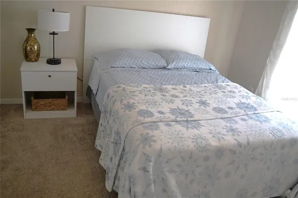 a bed sitting in a bedroom next to a window