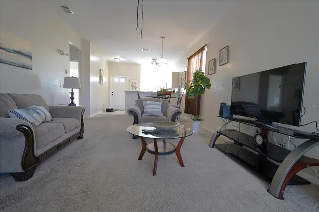 a living room with furniture and a chandelier