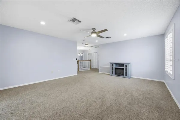 an empty room with windows and fireplace