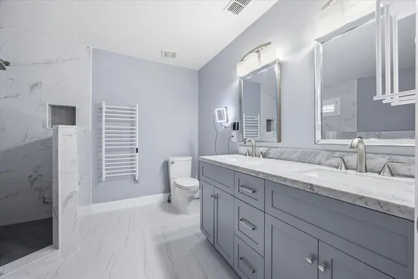 a spacious bathroom with a granite countertop sink a toilet and a mirror