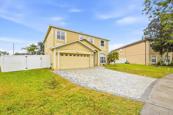 a view of an house with backyard and tree