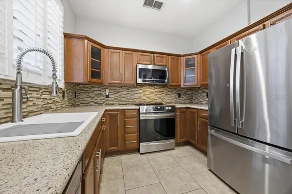 a kitchen with stainless steel appliances granite countertop a refrigerator sink and microwave