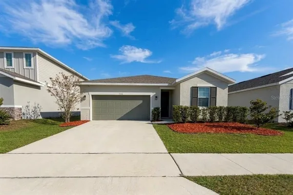 a front view of a house with a yard and garage