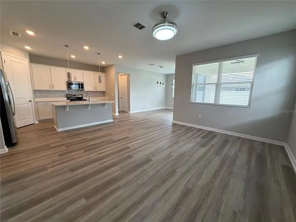 a view of kitchen with wooden floor and electronic appliances