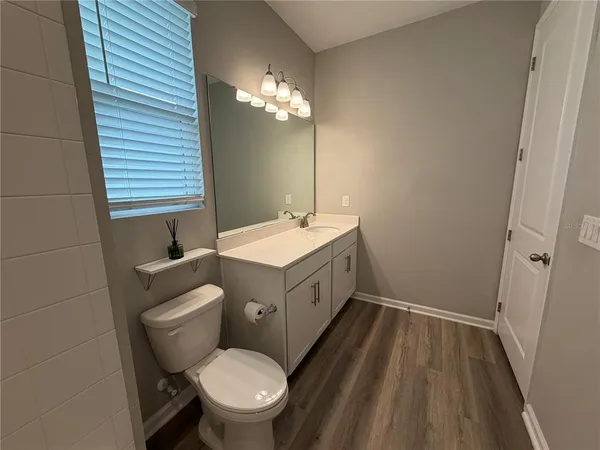 a bathroom with a sink a toilet a mirror and shower