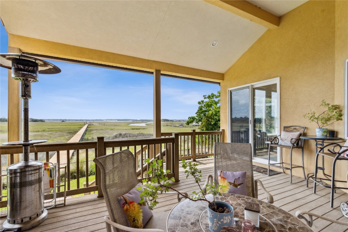 3045 Riverside Drive Fernandina Beach, FL 32034 - Photo 24 of 35 a balcony with wooden floor table and chairs