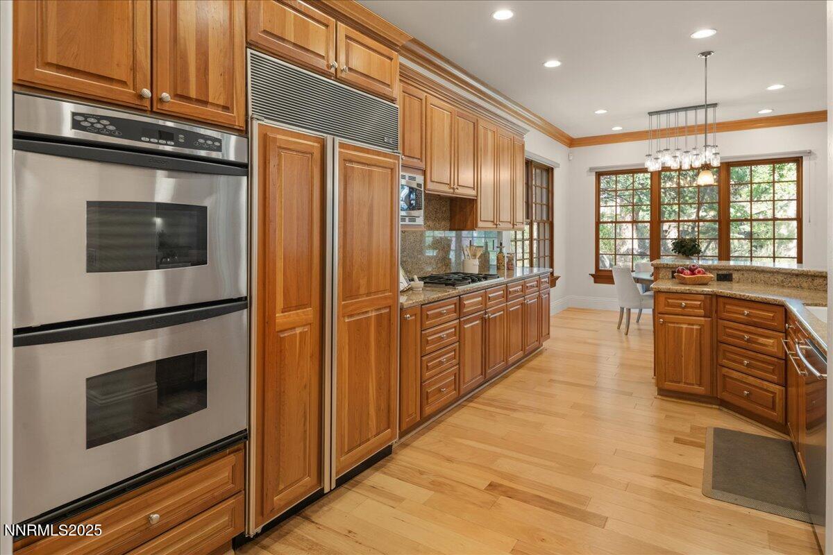 6410 Zermatt Court Reno, NV 89511 - Photo 12 of 52 a kitchen with stainless steel appliances kitchen island granite countertop a stove a sink and a microwave