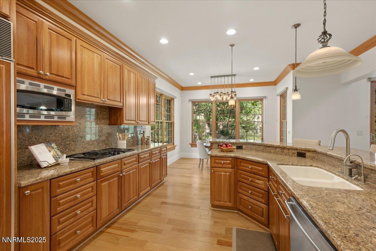 6410 Zermatt Court Reno, NV 89511 - Photo 14 of 52 a kitchen with kitchen island granite countertop a sink a counter space appliances and cabinets