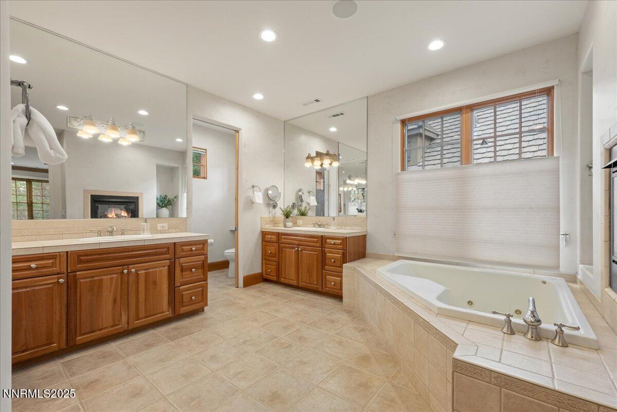 6410 Zermatt Court Reno, NV 89511 - Photo 35 of 52 a large bathroom with a large tub a sink double vanity and a shower