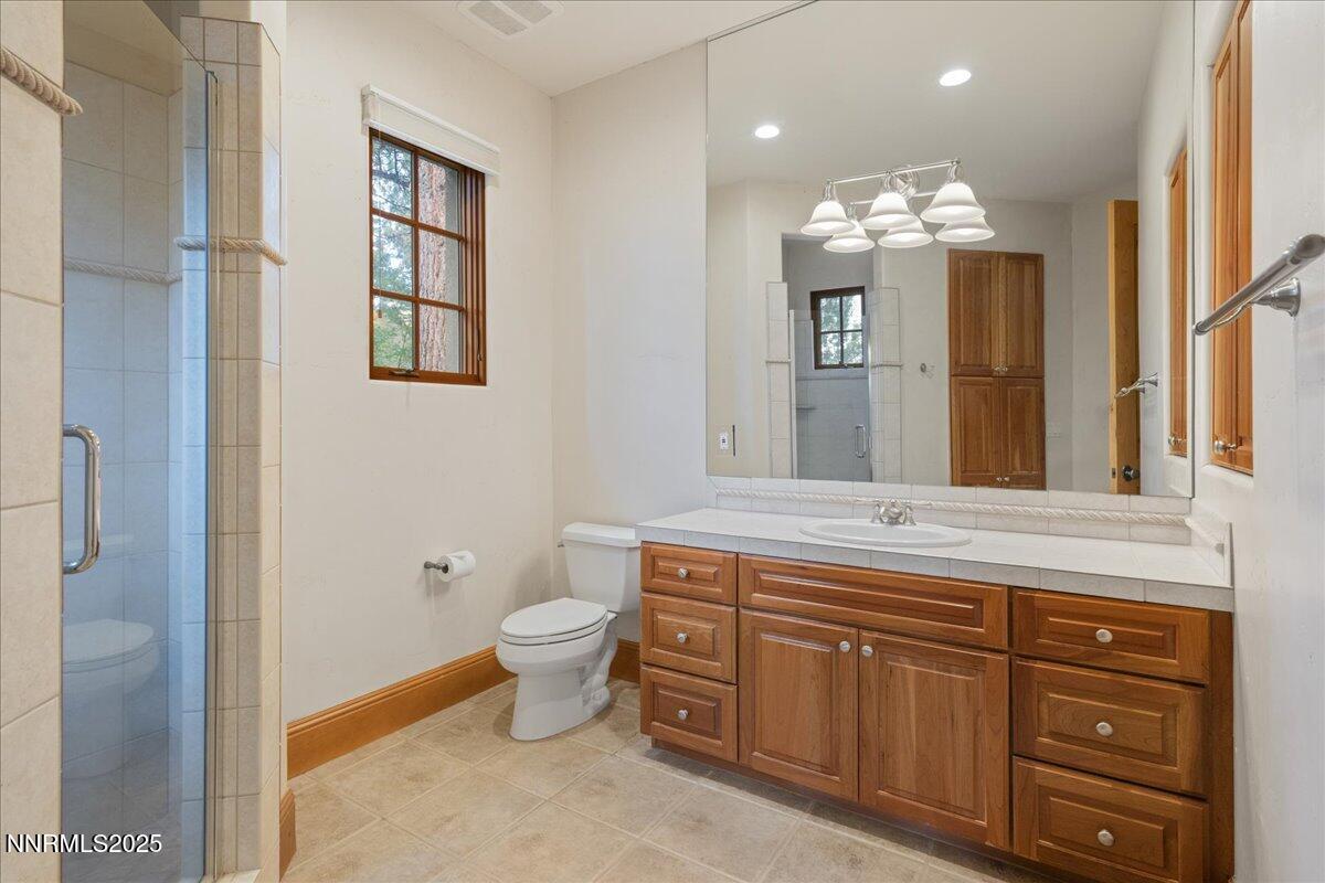 6410 Zermatt Court Reno, NV 89511 - Photo 43 of 52 a spacious bathroom with double vanity a toilet a sink and a window