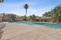 7701 West Robindale Road, Unit 277 Las Vegas, NV 89113 - Photo 32 of 33 Palm-lined oasis awaits with this inviting community pool, perfect for relaxation and recreation.