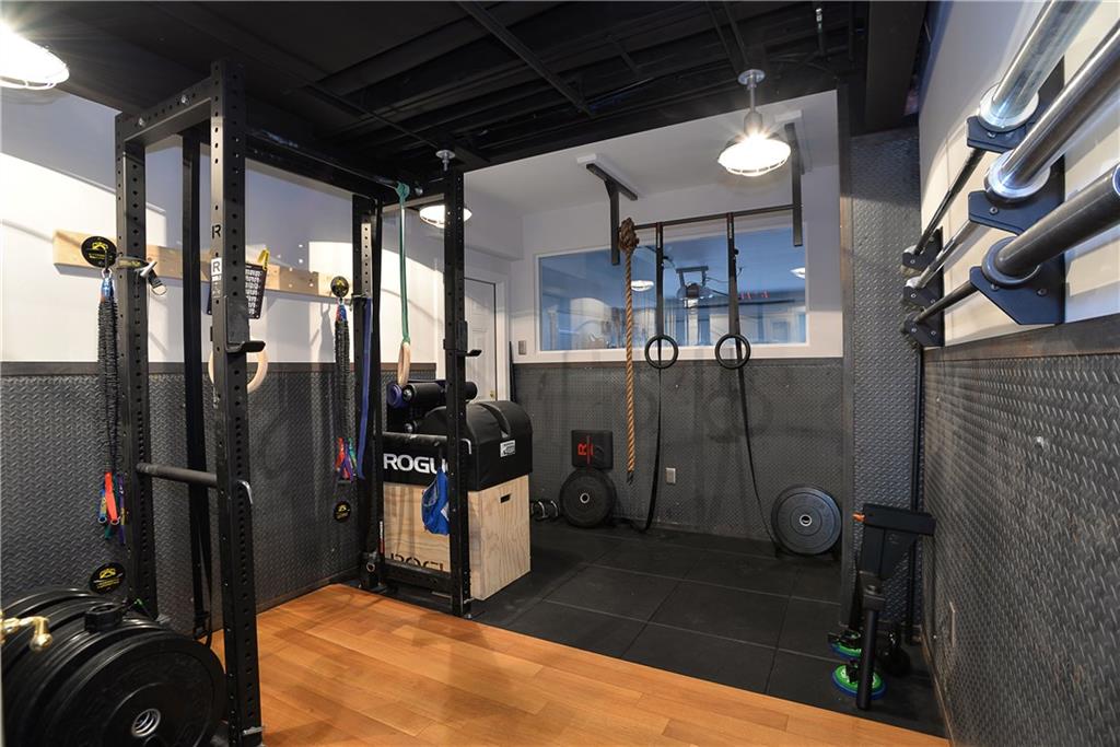 32 Newgate Road Pittsburgh, PA 15202 - Photo 22 of 25 A second gym created for heavier lifting and cross-fit exercises looks outside when the garage doors are opened. One can exit the gym to the 3 car internal garage from this well-appointed gym. This is ideal for an athlete.