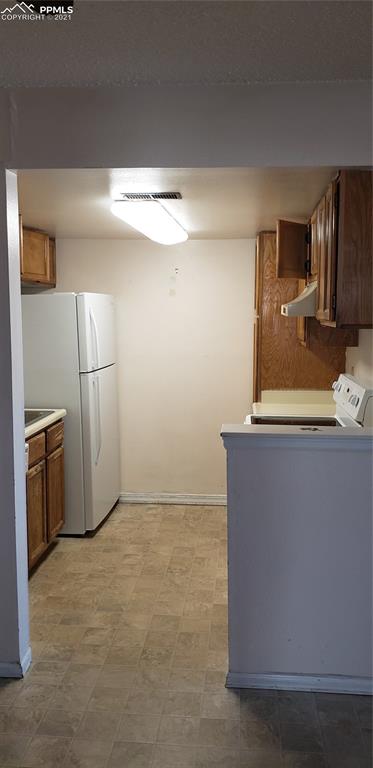 814 Tenderfoot Hill Road, Unit 102 Colorado Springs, CO 80906 - Photo 5 of 11 a view of a refrigerator in kitchen and an empty room