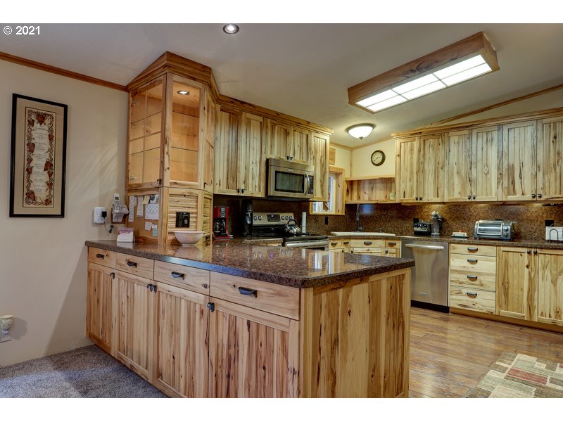 67367 Gist Road Bend, OR 97703 - Photo 4 of 32 a kitchen with stainless steel appliances granite countertop a stove a sink dishwasher and a microwave oven with cabinets