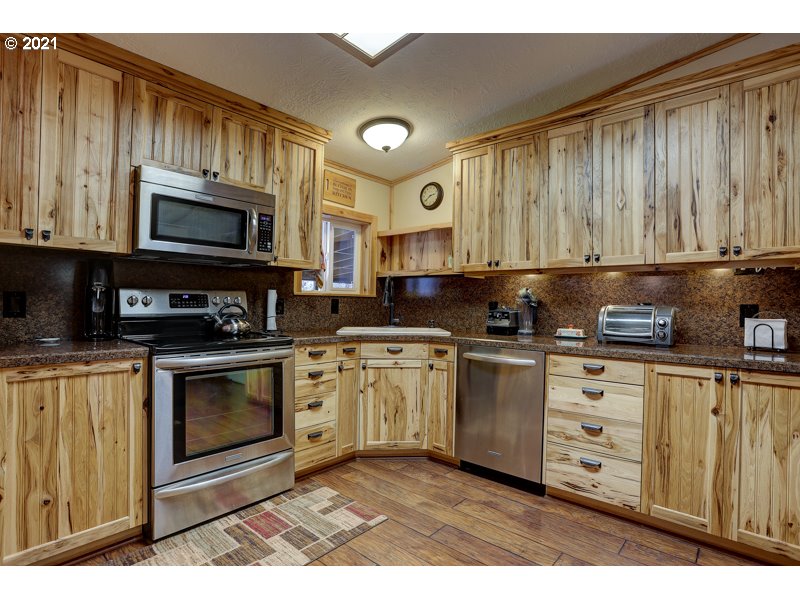 67367 Gist Road Bend, OR 97703 - Photo 5 of 32 a kitchen with stainless steel appliances granite countertop a stove a sink and a microwave