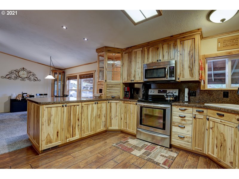 67367 Gist Road Bend, OR 97703 - Photo 6 of 32 a kitchen with stainless steel appliances granite countertop a stove a sink and a microwave