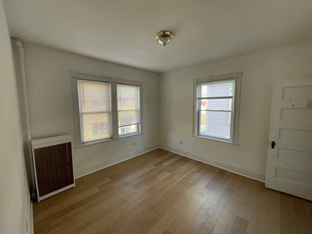 34 Channing Street, Unit 2 Newton, MA 02458 - Photo 15 of 23 an empty room with wooden floor and windows
