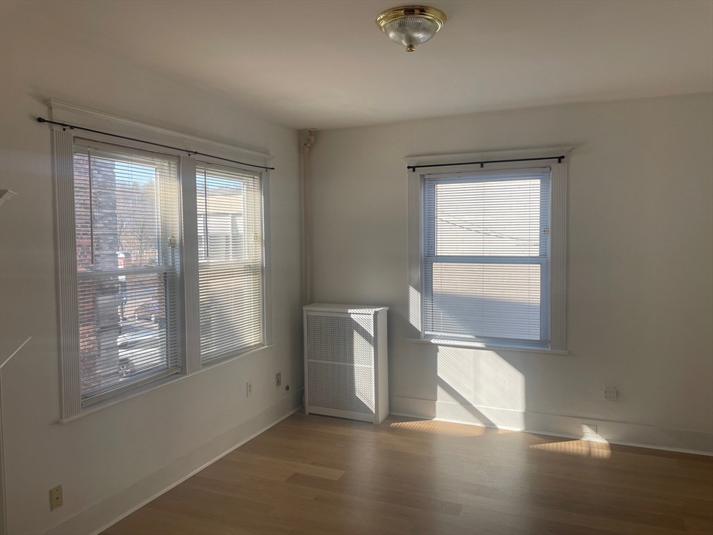 34 Channing Street, Unit 2 Newton, MA 02458 - Photo 23 of 23 an empty room with wooden floor and windows
