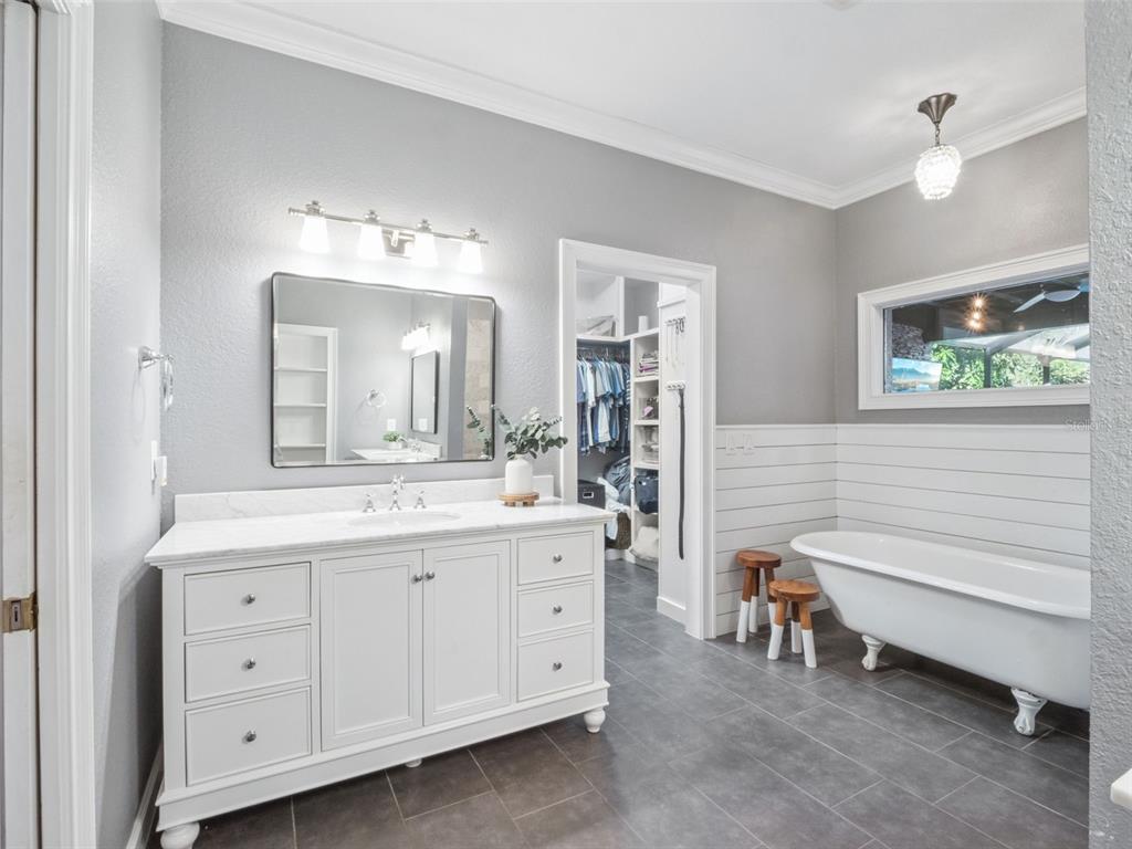 2509 Ridgewind Way Windermere, FL 34786 - Photo 14 of 38 a bathroom with a double vanity sink a mirror a bathtub and a window