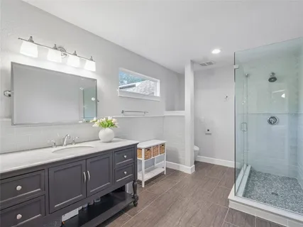 a spacious bathroom with a double vanity sink mirror and shower