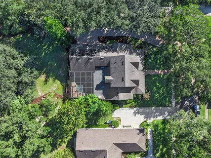 an aerial view of a house with a yard fountain and large tree