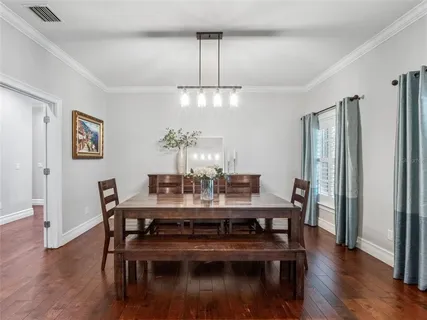 a view of a dining room with furniture wooden floor and chandelier