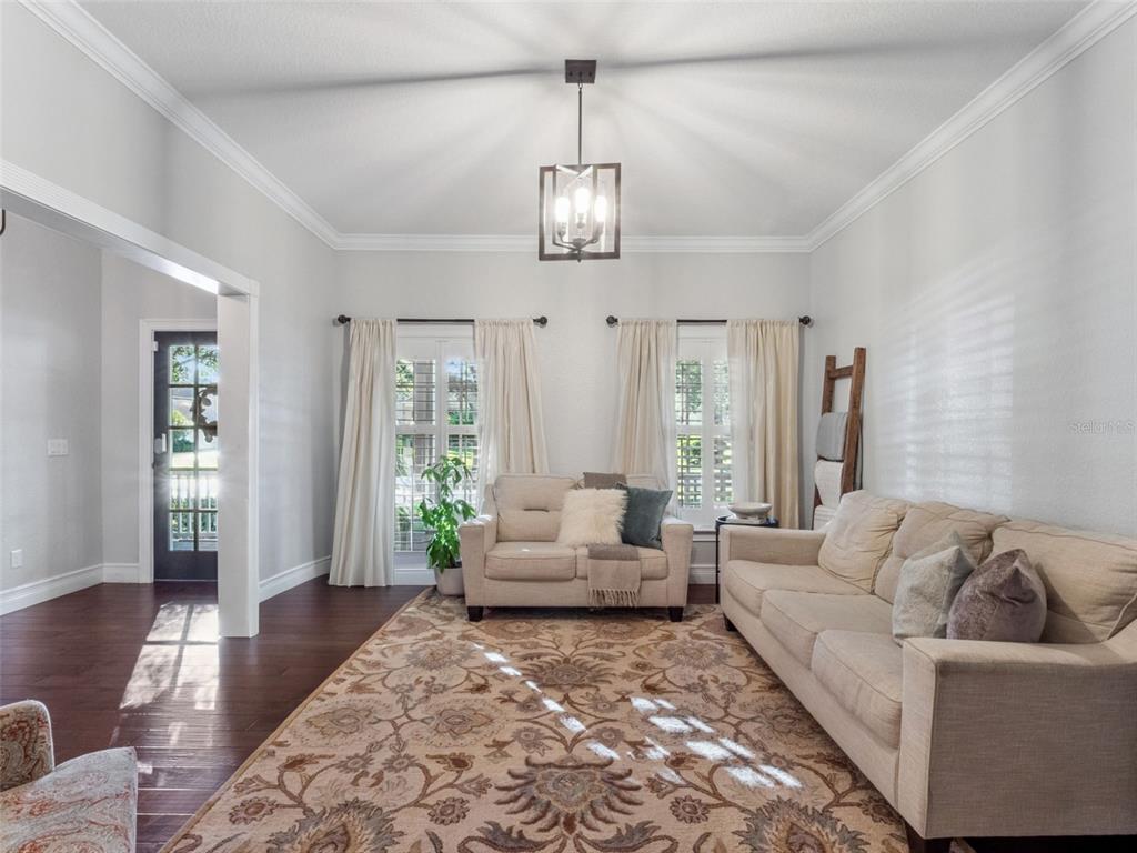 2509 Ridgewind Way Windermere, FL 34786 - Photo 8 of 38 a living room with furniture chandelier and wooden floor
