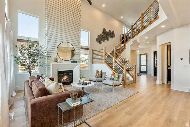 2458 West Aurora Avenue, Unit 287 Mapleton, UT 84664 - Photo 7 of 24 Living area featuring a towering ceiling, light wood finished floors, recessed lighting, a glass covered fireplace, and stairway