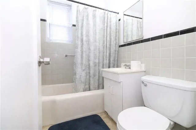 a white toilet sitting next to a bath tub
