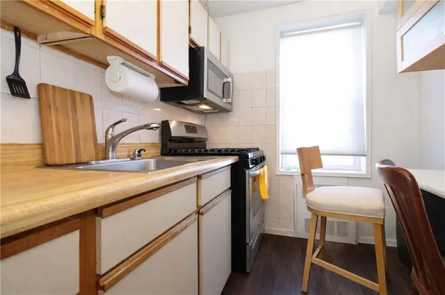 a kitchen with a sink cabinets and wooden floor