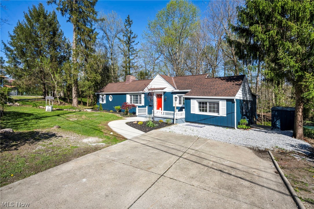 7339 River Road Olmsted Falls, OH 44138 - Photo 3 of 45 Blue siding exterior featuring a red entry door, white trim, and white window shutters