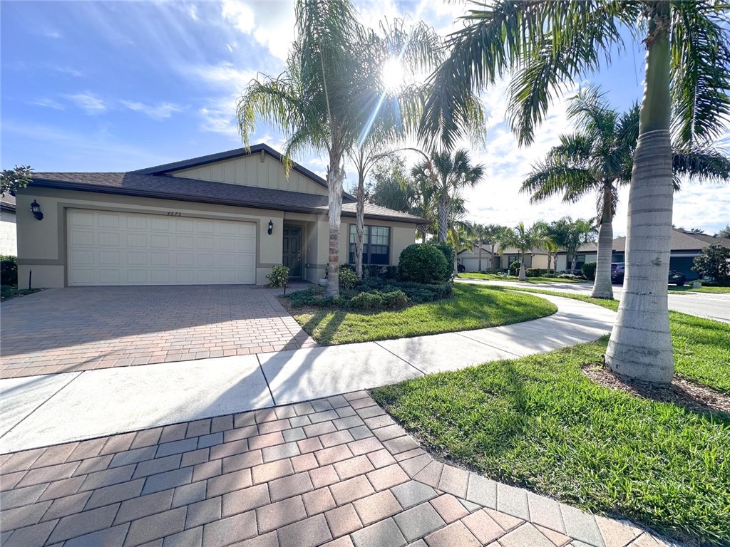 4675 Indigo Way Vero Beach, FL 32967 - Photo 1 of 19 a front view of a house with a yard and potted plants
