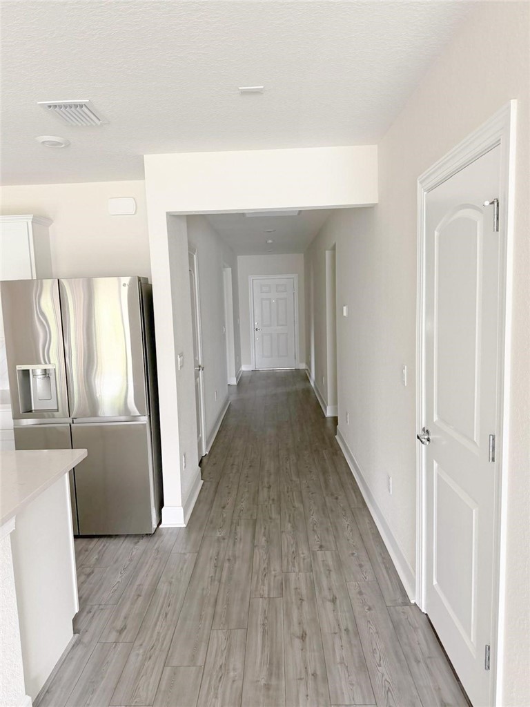 4675 Indigo Way Vero Beach, FL 32967 - Photo 9 of 19 a view of a hallway with wooden floor