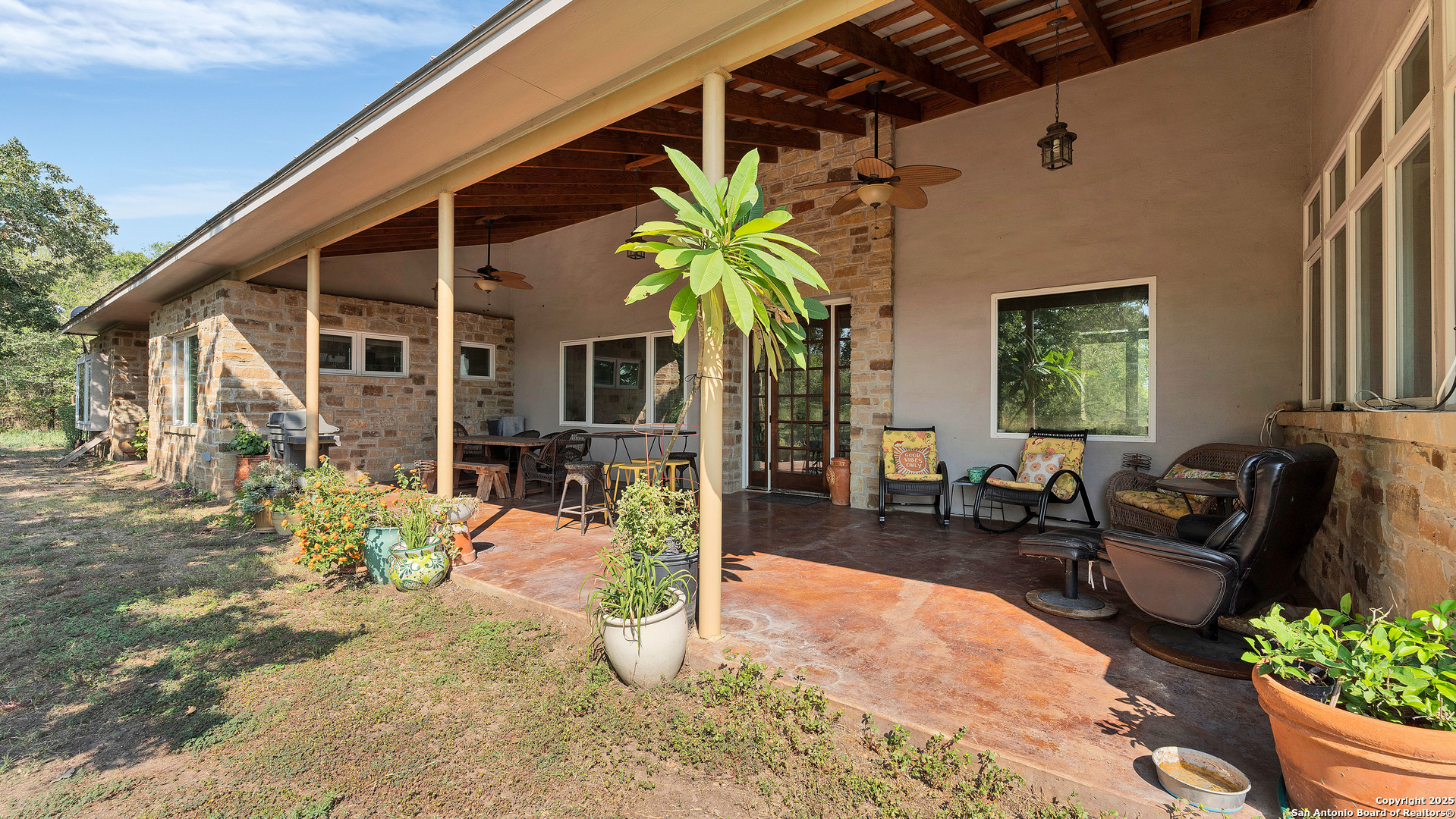 475 Jackson Road Kingsbury, TX 78638 - Photo 36 of 44 a view of a patio with couches table and chairs potted plants and floor to ceiling window
