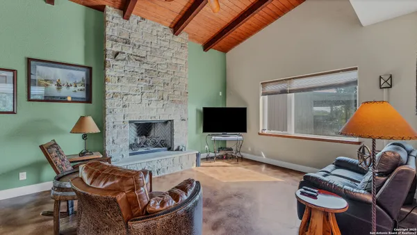 a living room with furniture a flat screen tv and a fireplace