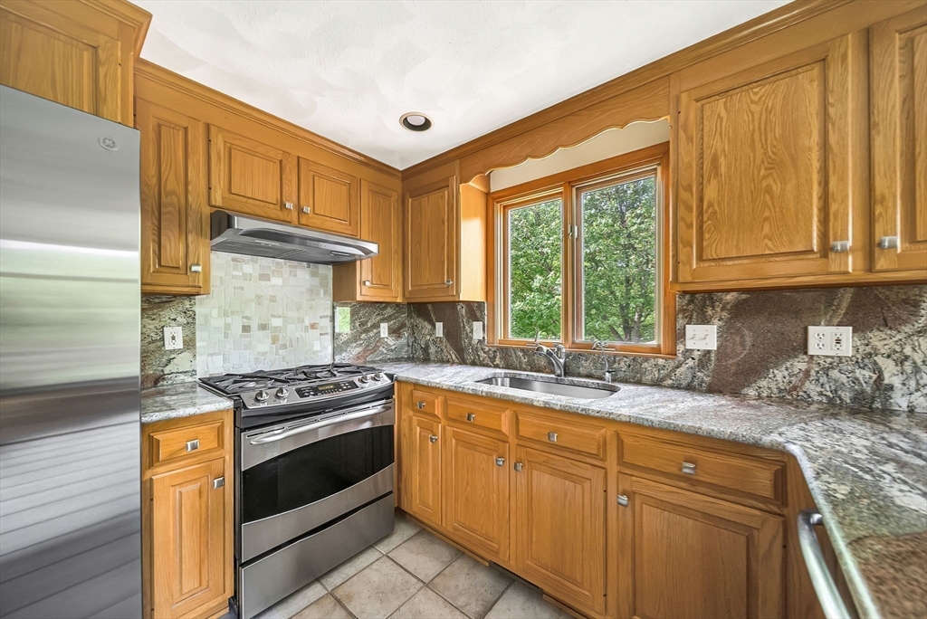 83 Jefferson Road Franklin, MA 02038 - Photo 5 of 34 a kitchen with granite countertop a sink stove and cabinets