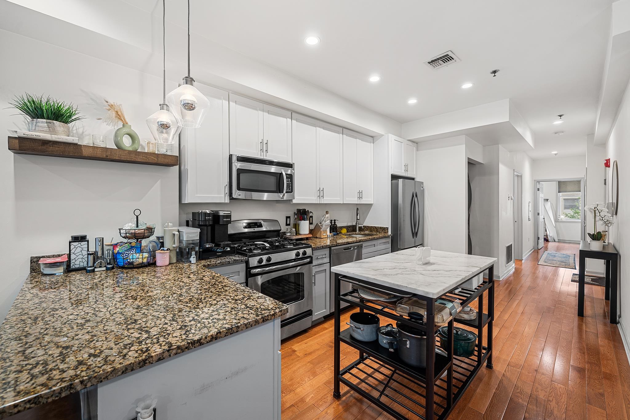 307 1st Street, Unit 2 Hoboken, NJ 07030 - Photo 5 of 20 a kitchen with stainless steel appliances granite countertop a sink stove and refrigerator