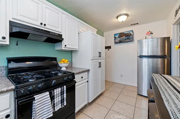 a kitchen with a refrigerator and a stove top oven