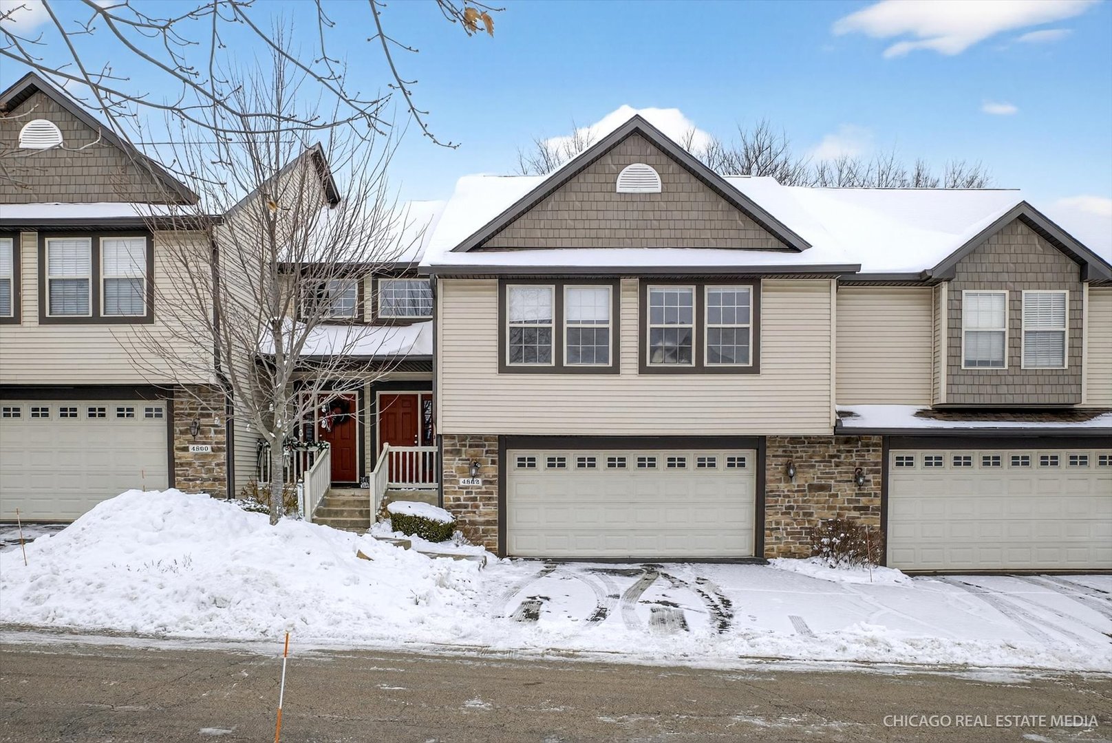 a front view of a house with a yard covered with snow