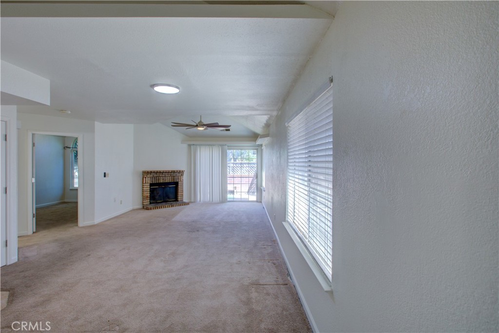 1247 Aspen Street Merced, CA 95340 - Photo 3 of 22 a view of an empty room with a fireplace and a window