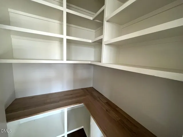 a view of an empty room with wooden walls and stairs