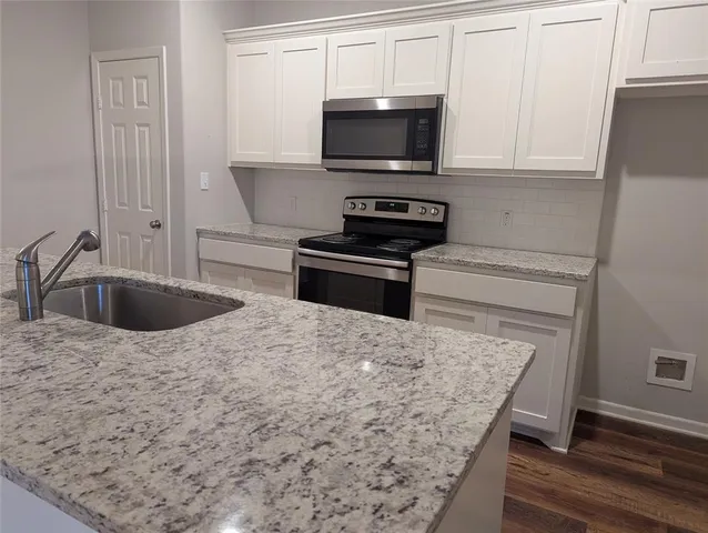 a kitchen with sink a microwave and cabinets