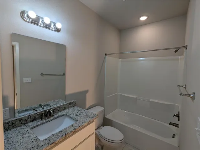 a bathroom with a granite countertop sink a shower and a mirror