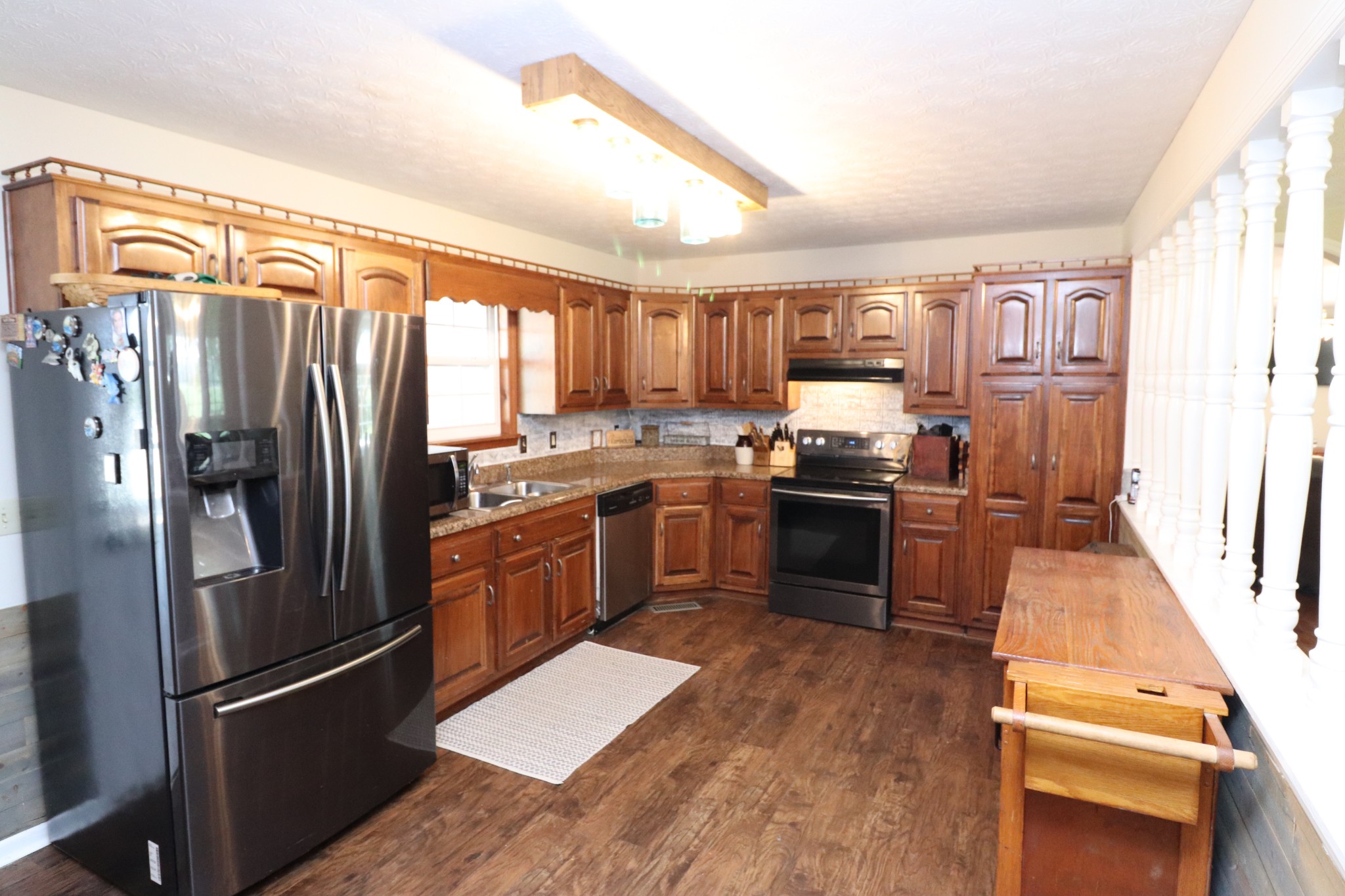 4753 Akersville Road Lafayette, TN 37083 - Photo 4 of 50 a kitchen with granite countertop stainless steel appliances and wooden cabinets