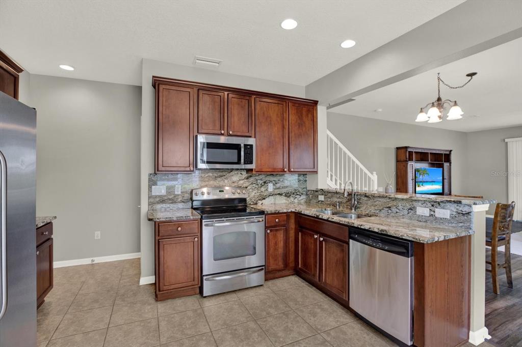 10228 Red Currant Court Riverview, FL 33578 - Photo 16 of 37 a kitchen with a sink stove and microwave