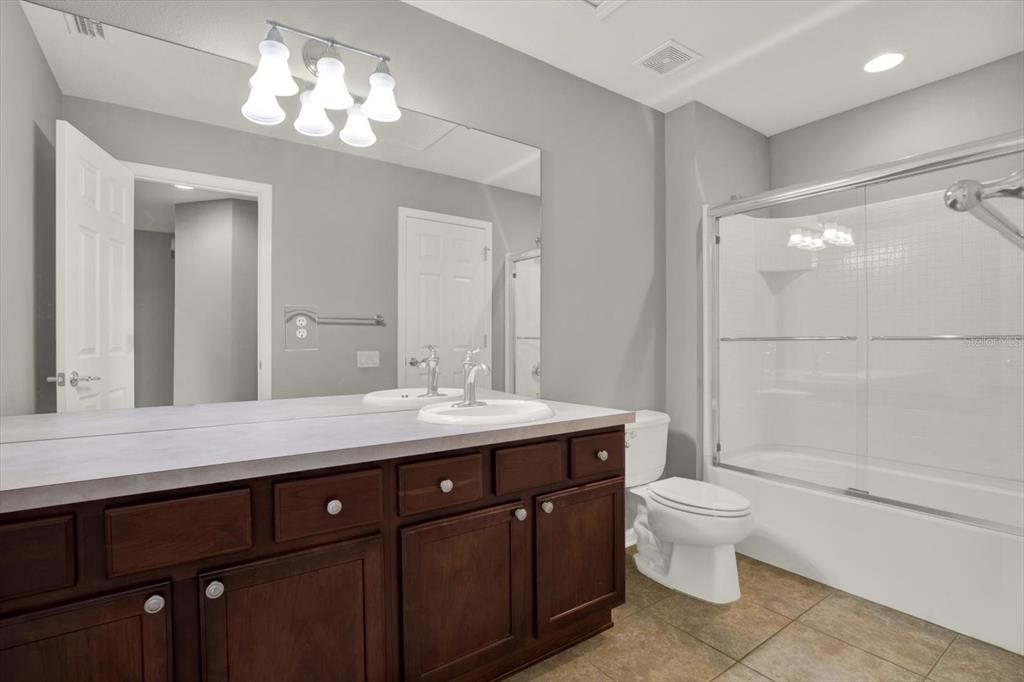 10228 Red Currant Court Riverview, FL 33578 - Photo 26 of 37 a spacious bathroom with a granite countertop toilet a sink and a mirror